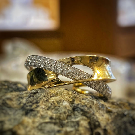 Photo of Looped Diamond and Gold Ring in a decorative scene, designed by , available at Plumb Gold & Plumb Silver