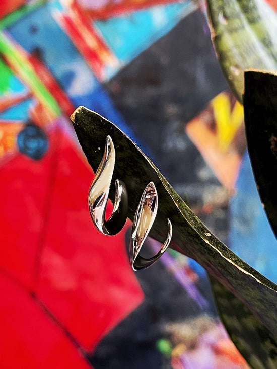 Photo of "Love" J-hoop Earrings in a decorative scene, designed by , available at Plumb Gold & Plumb Silver