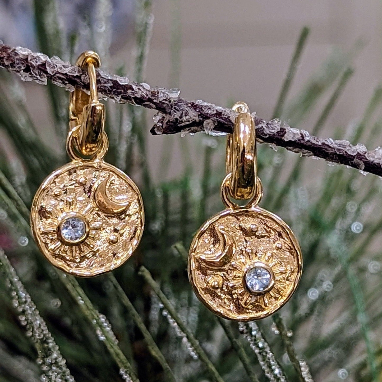 Photo of "Luna" Celestial Dangle Hoop Earrings in a decorative scene, designed by , available at Plumb Gold & Plumb Silver