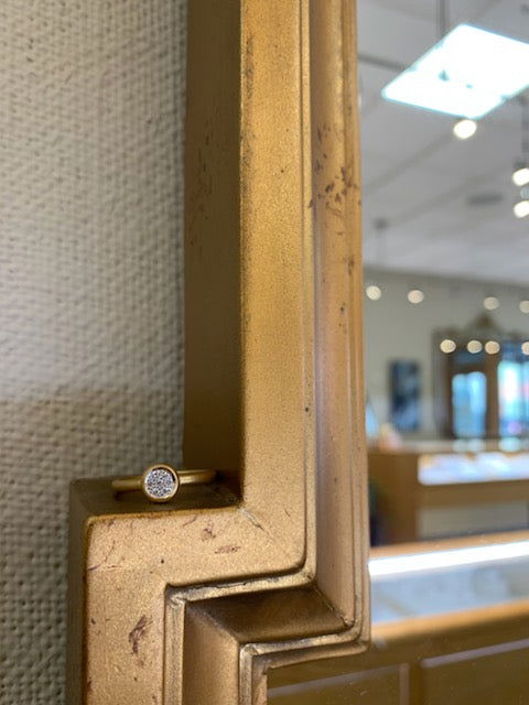 Photo of Matte Pavé Bezel Ring in a decorative scene, designed by , available at Plumb Gold & Plumb Silver