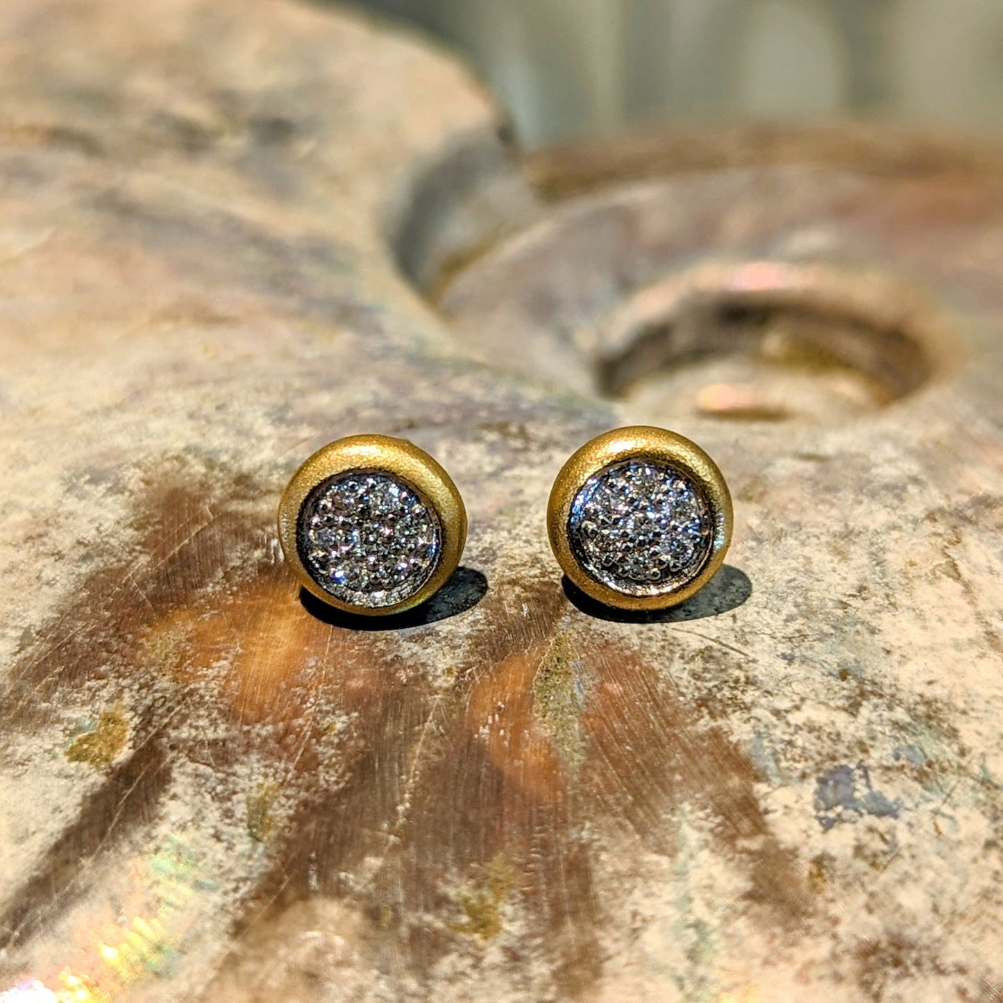 Photo of Matte Pavé Circle Studs in a decorative scene, designed by , available at Plumb Gold & Plumb Silver