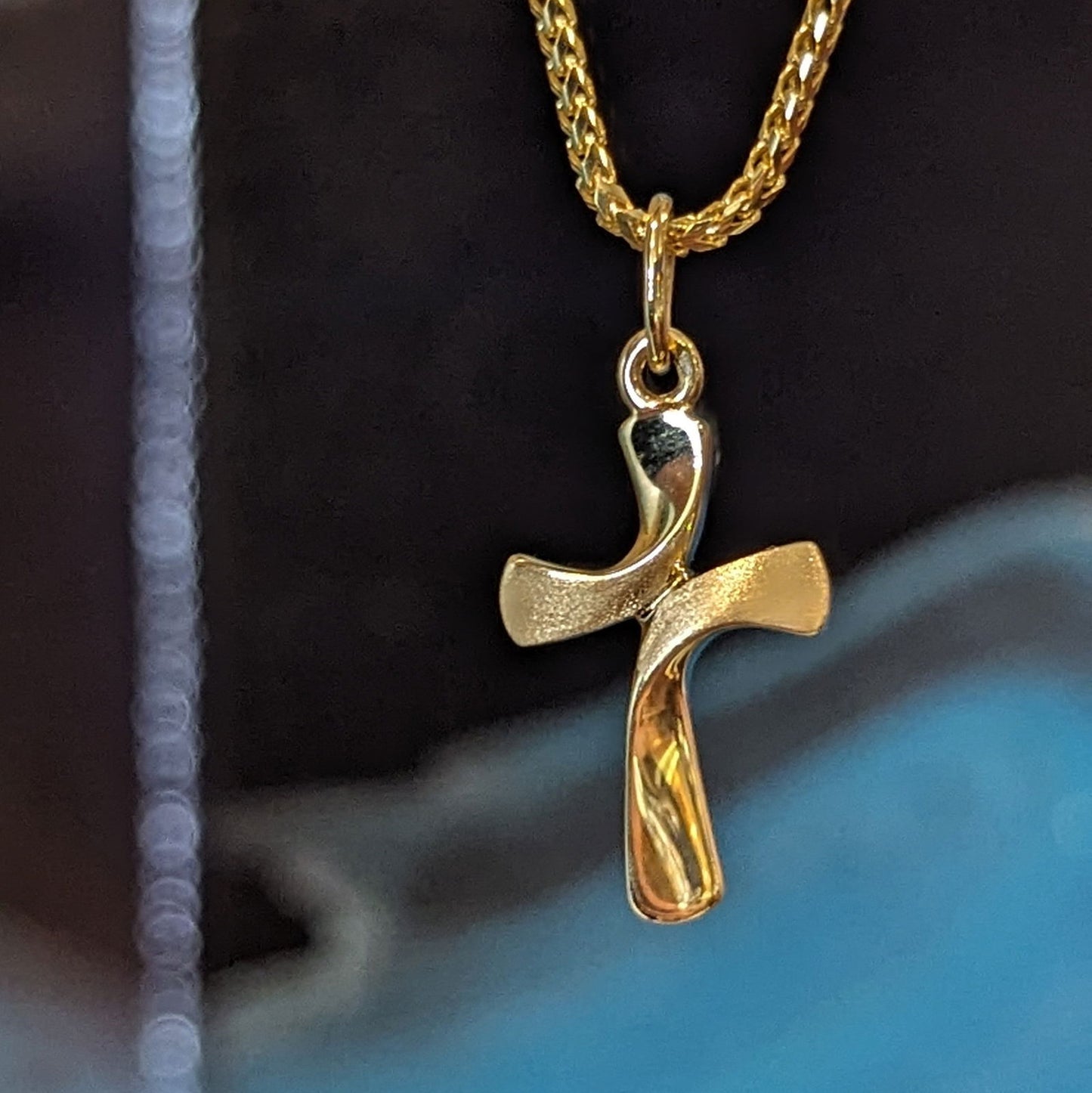 Photo of Matte Sweep Cross in a decorative scene, designed by , available at Plumb Gold & Plumb Silver