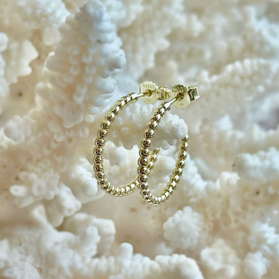Photo of Medium Bubble Hoops in a decorative scene, designed by -, available at Plumb Gold & Plumb Silver