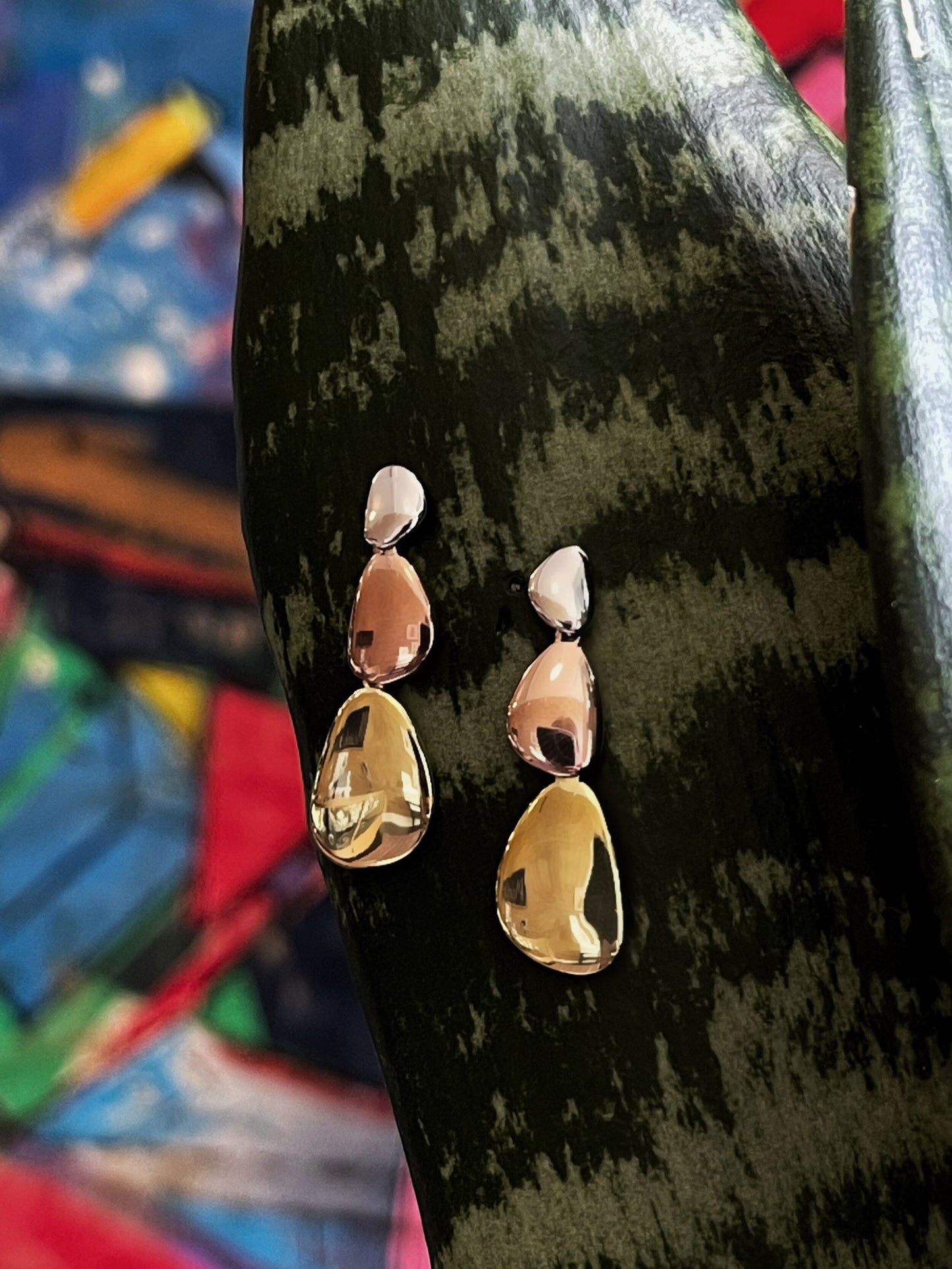 Photo of "Mercury" Dangle Earrings in a decorative scene, designed by , available at Plumb Gold & Plumb Silver