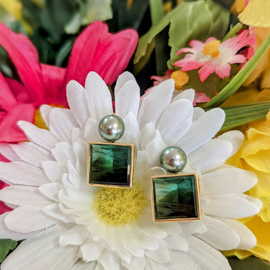 Photo of Mirror Cut Tourmaline and Tahitian Pearl Earrings in a decorative scene, designed by , available at Plumb Gold & Plumb Silver