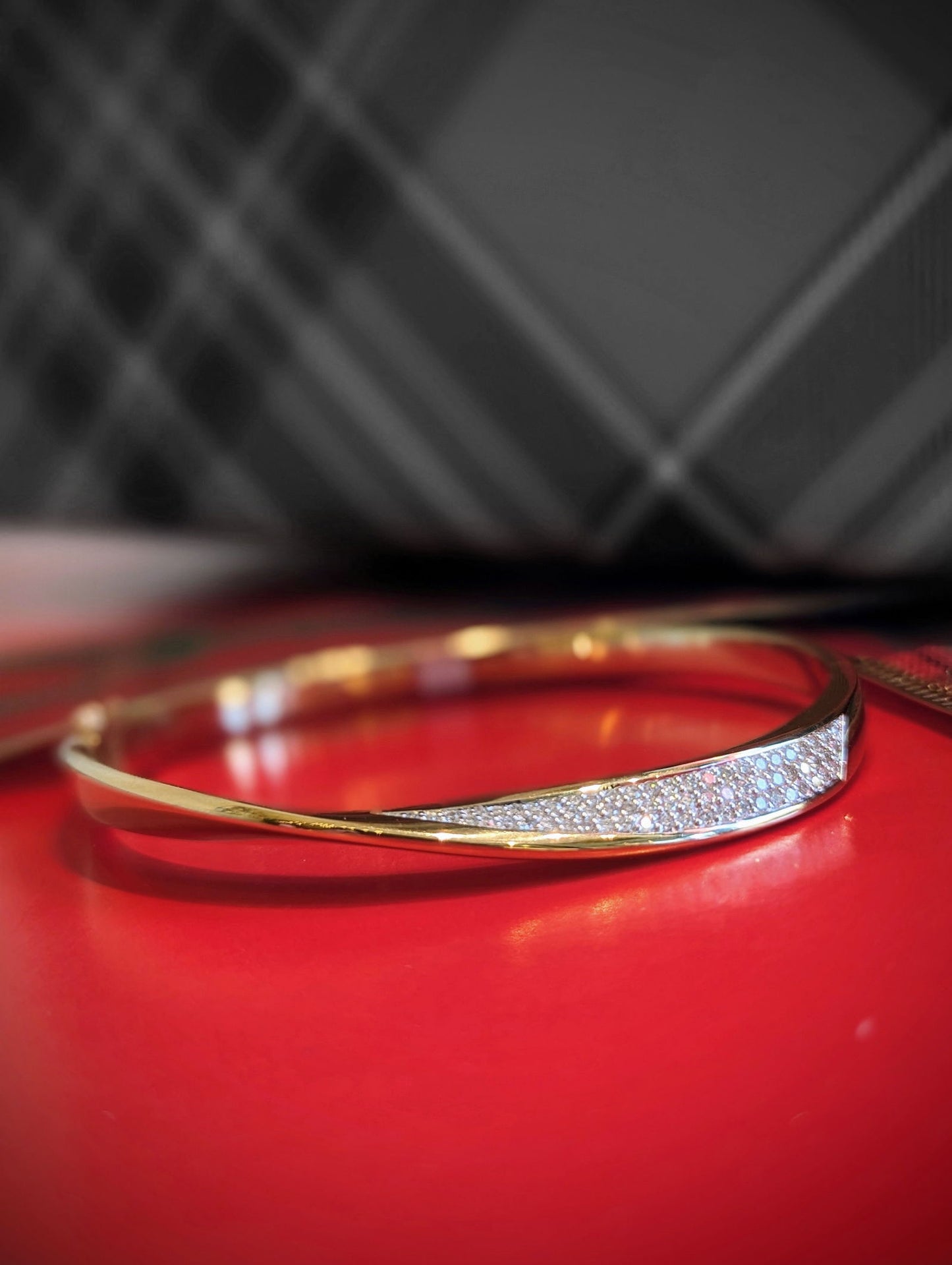 Photo of Mobius Bangle in a decorative scene, designed by , available at Plumb Gold & Plumb Silver