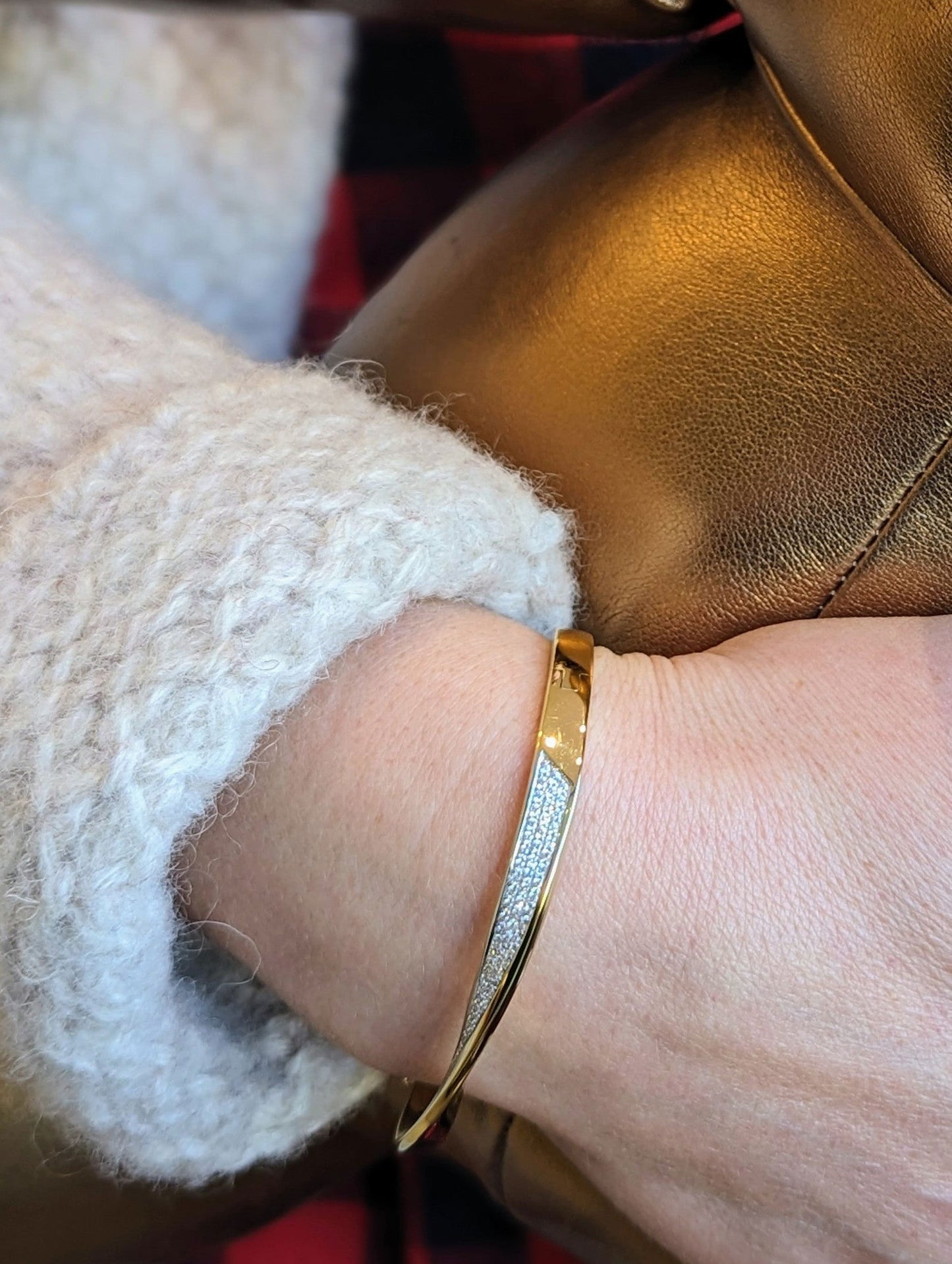 Photo of Mobius Bangle in a decorative scene, designed by , available at Plumb Gold & Plumb Silver