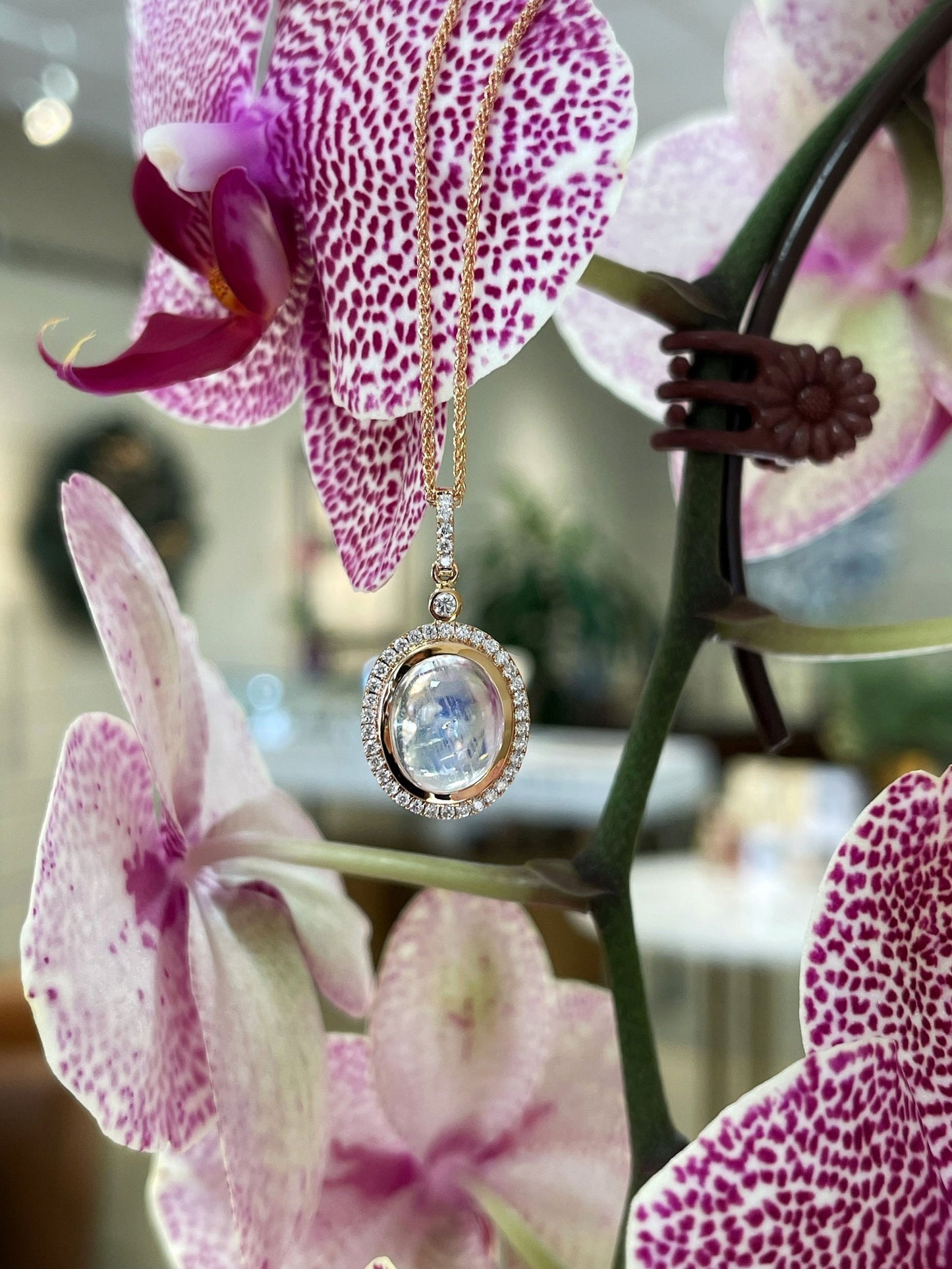 Photo of Moonstone Pendant in a decorative scene, designed by , available at Plumb Gold & Plumb Silver