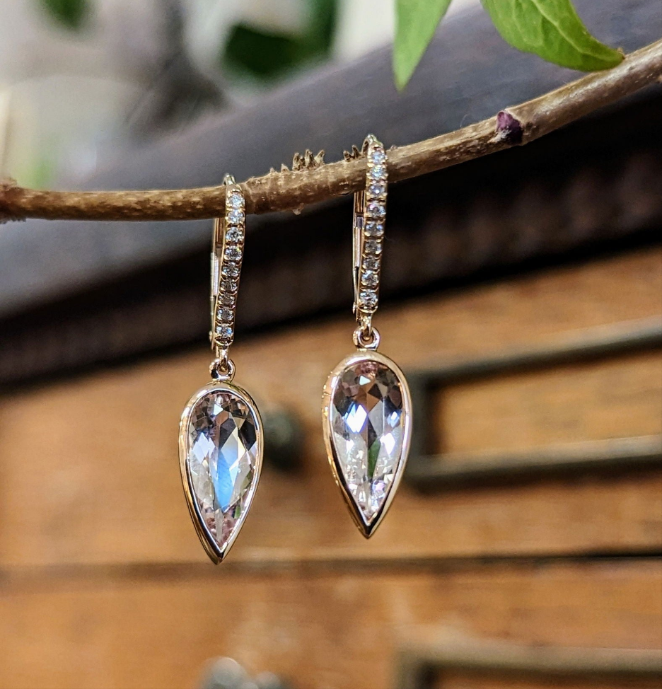 Photo of Morganite Bezel Dangle Earrings in a decorative scene, designed by -, available at Plumb Gold & Plumb Silver