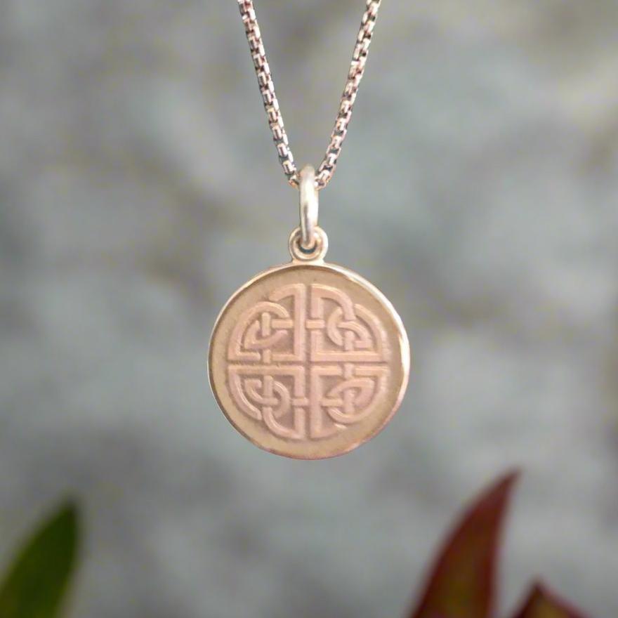 Photo of Mother and Daughter Small Celtic Knot Pendant in a decorative scene, designed by , available at Plumb Gold & Plumb Silver