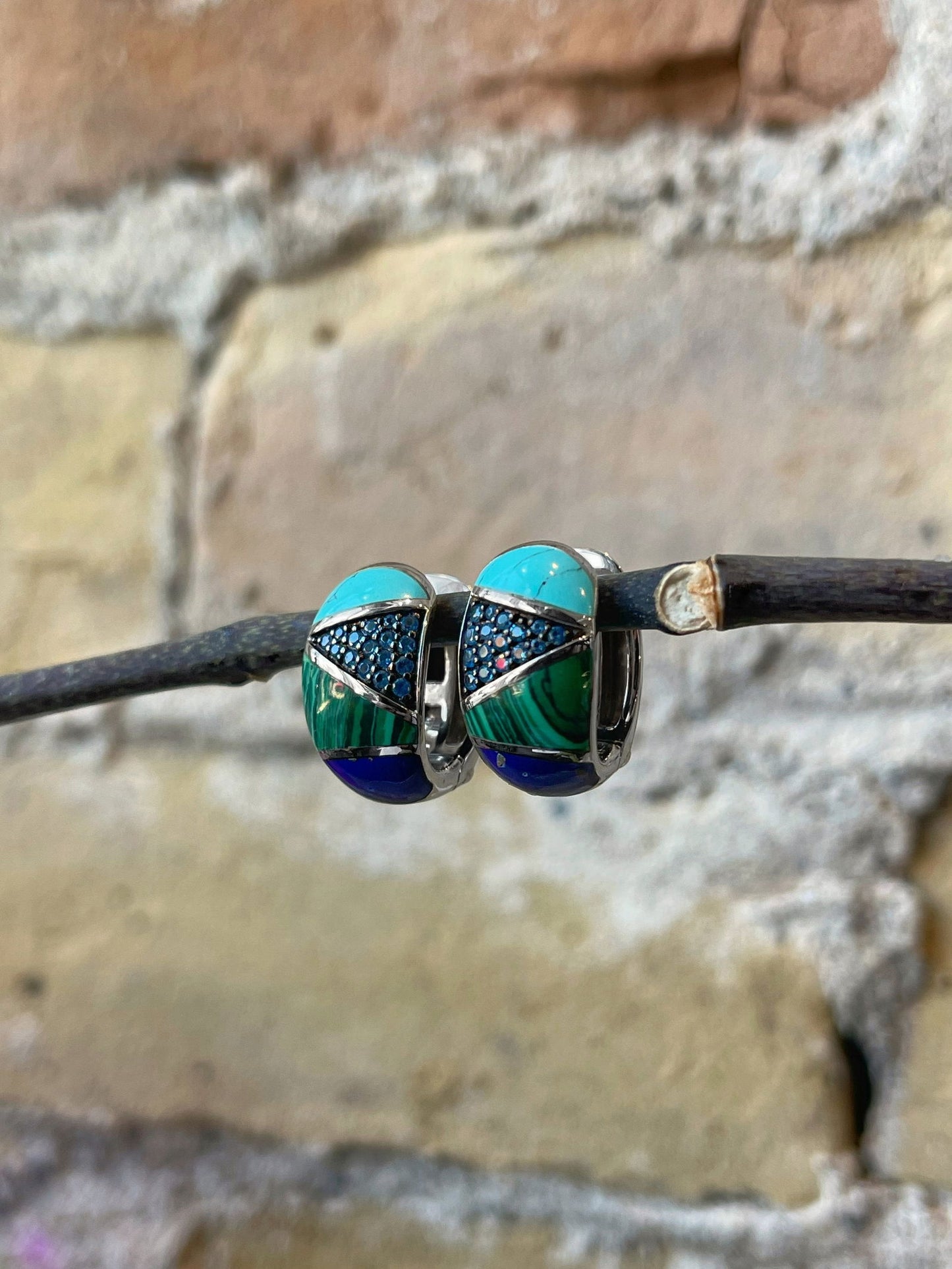 Photo of Multi-Stone Hoops in a decorative scene, designed by , available at Plumb Gold & Plumb Silver