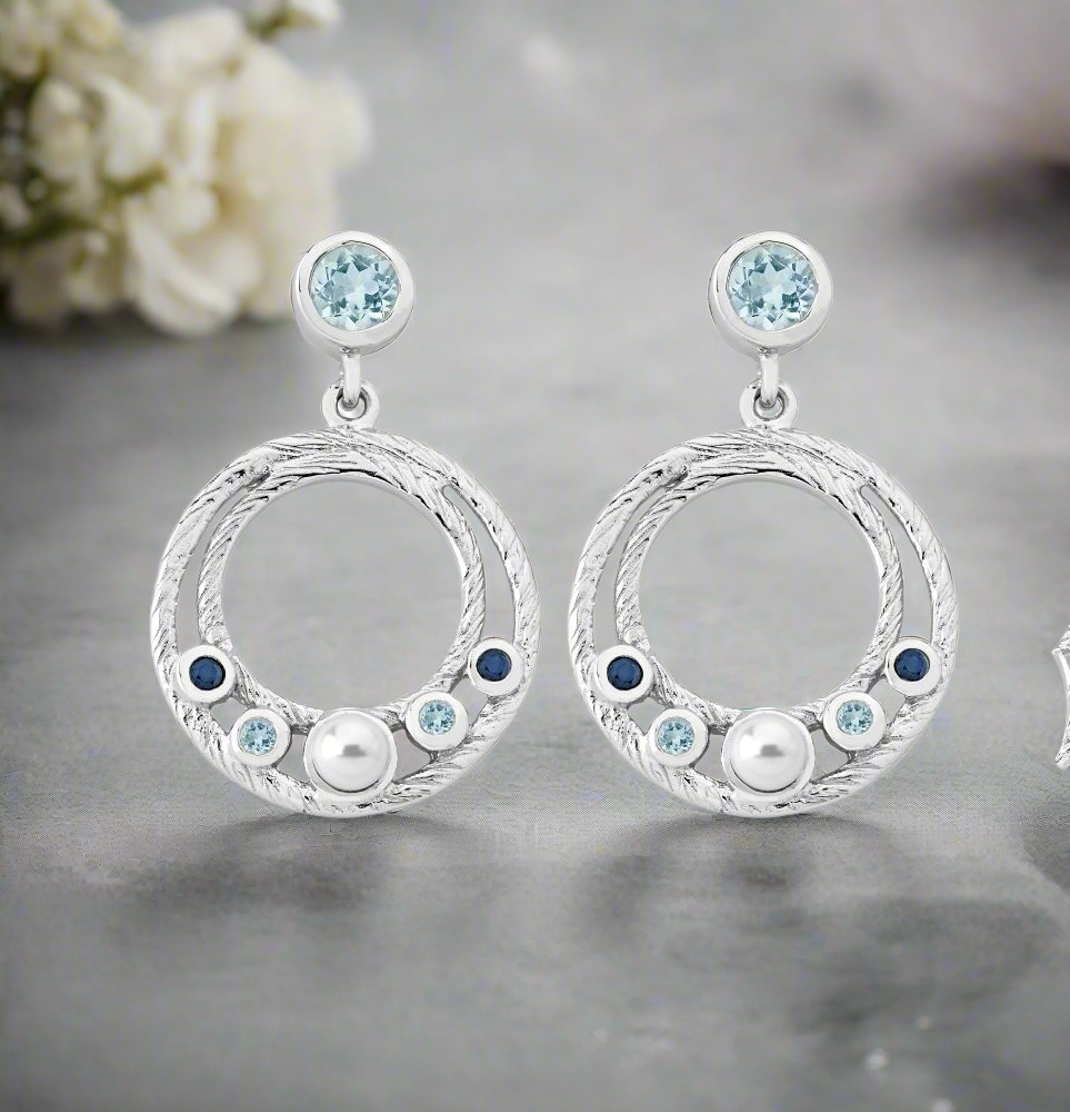 Photo of Ocean Dangle Earrings in a decorative scene, designed by , available at Plumb Gold & Plumb Silver