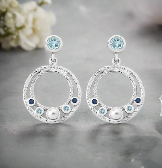 Photo of Ocean Dangle Earrings in a decorative scene, designed by , available at Plumb Gold & Plumb Silver
