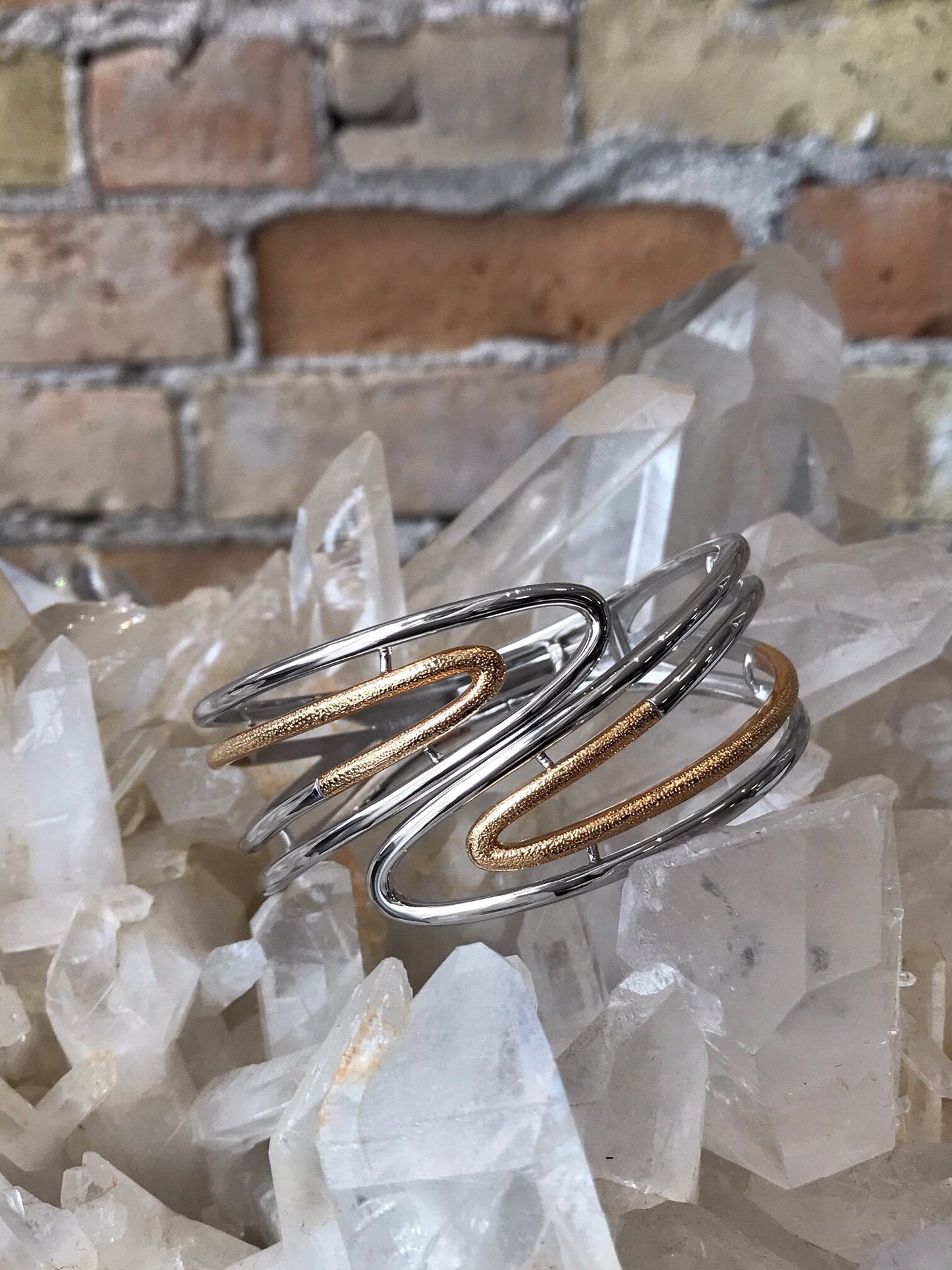 Photo of Open Bypass Bangle in a decorative scene, designed by , available at Plumb Gold & Plumb Silver