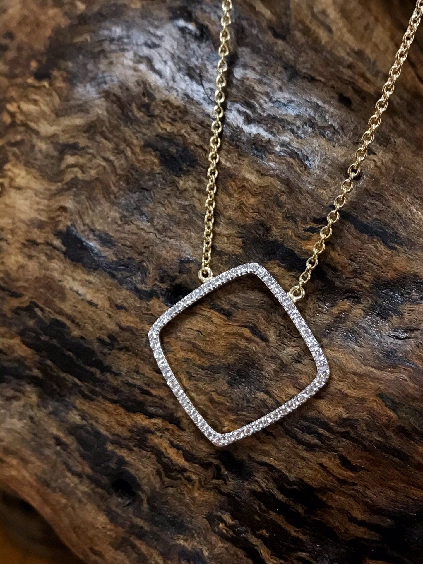 Photo of Open Diamond Necklace in a decorative scene, designed by , available at Plumb Gold & Plumb Silver