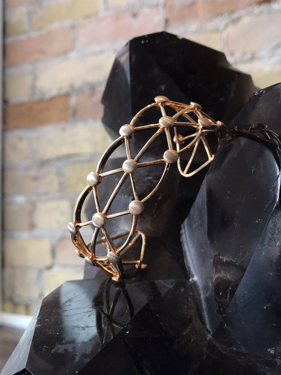 Photo of Open Lattice Cuff in a decorative scene, designed by , available at Plumb Gold & Plumb Silver