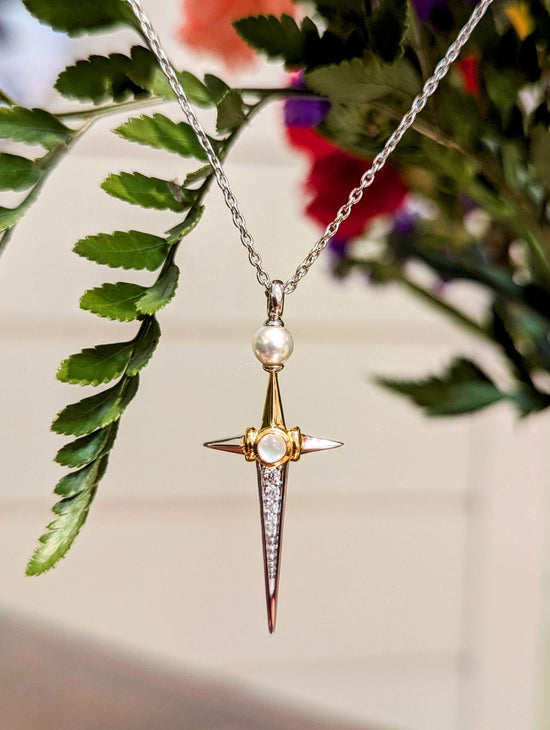 Photo of Pearl and cubic zirconia cross in a decorative scene, designed by , available at Plumb Gold & Plumb Silver