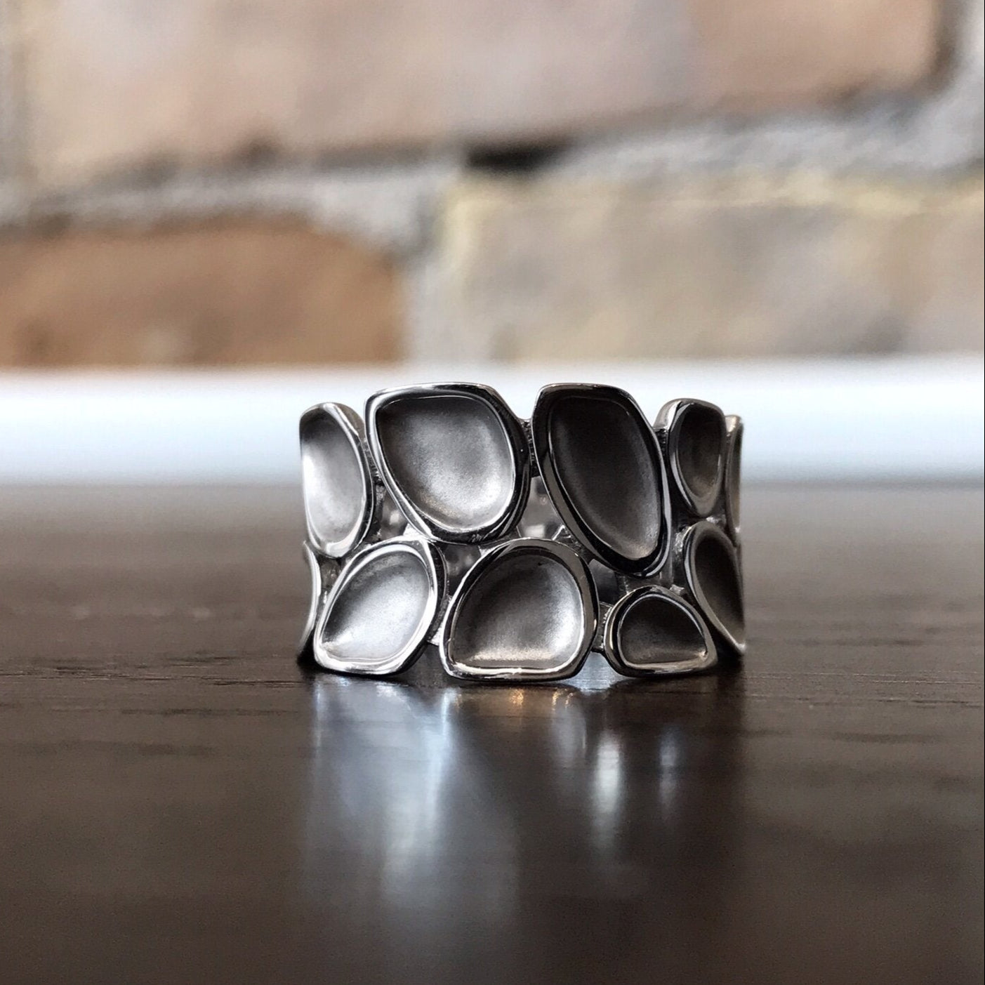 Photo of Pebble Ring in a decorative scene, designed by , available at Plumb Gold & Plumb Silver