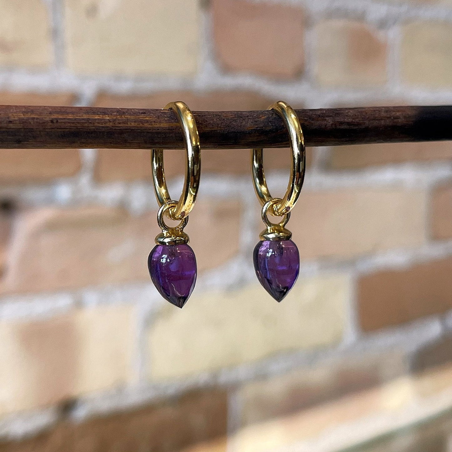 Photo of “Pendulum” Amethyst Dangles in a decorative scene, designed by , available at Plumb Gold & Plumb Silver