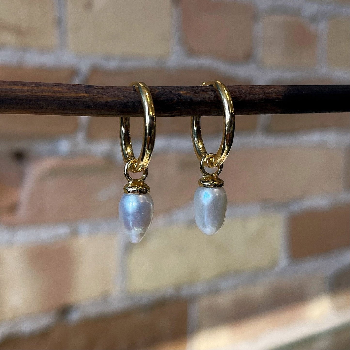 Photo of “Pendulum” Pearl Dangles in a decorative scene, designed by , available at Plumb Gold & Plumb Silver