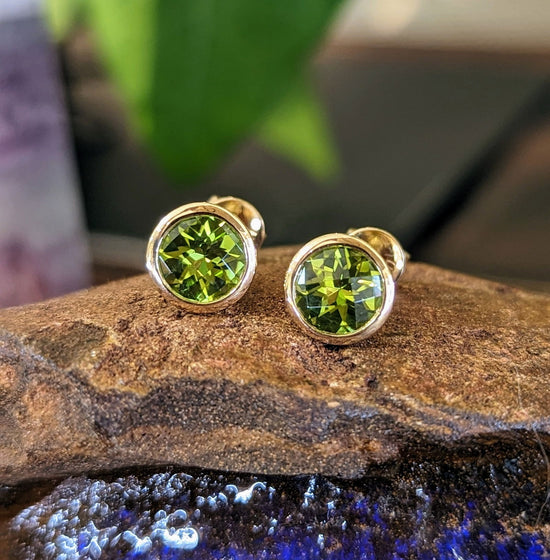 Photo of Peridot Bezel Studs in a decorative scene, designed by , available at Plumb Gold & Plumb Silver