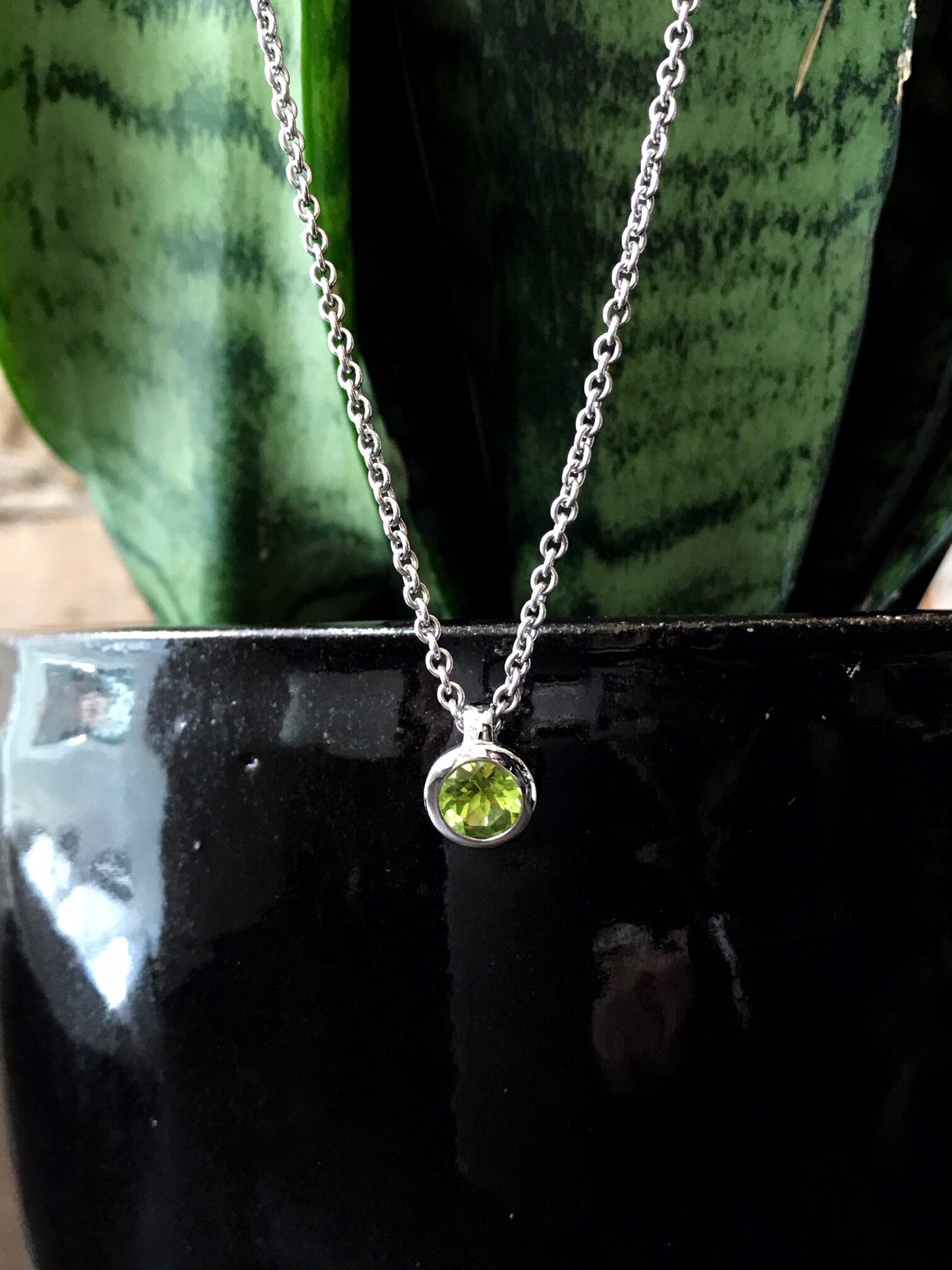 Photo of Peridot Pendant in a decorative scene, designed by , available at Plumb Gold & Plumb Silver