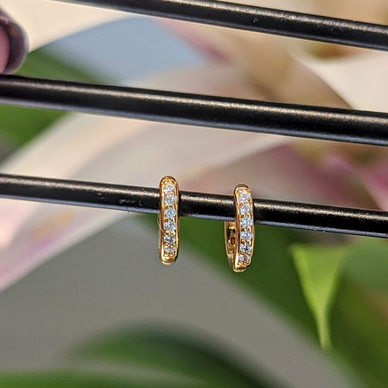 Photo of Petite CZ Hoops in a decorative scene, designed by , available at Plumb Gold & Plumb Silver