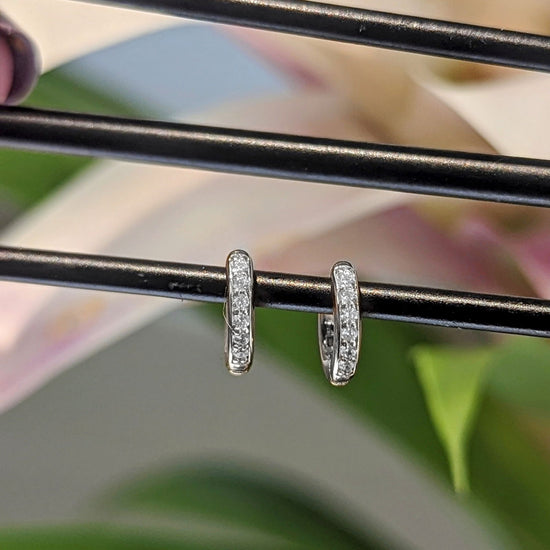 Photo of Petite CZ Hoops in a decorative scene, designed by , available at Plumb Gold & Plumb Silver