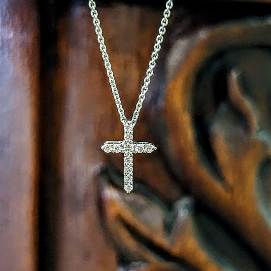 Photo of Petite Diamond Cross in a decorative scene, designed by , available at Plumb Gold & Plumb Silver