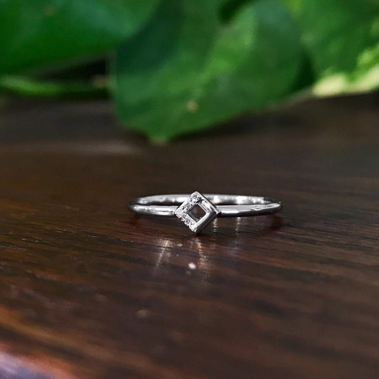 Photo of Petite Square Ring in a decorative scene, designed by , available at Plumb Gold & Plumb Silver