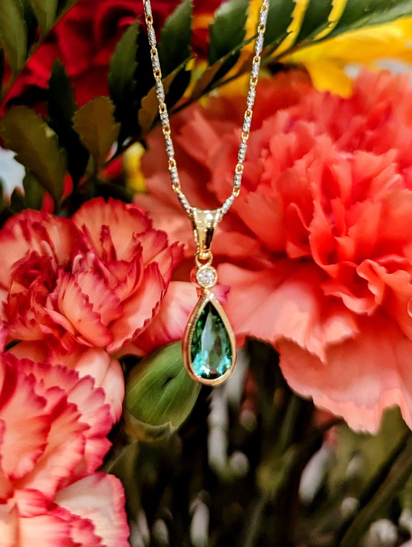 Photo of Petite Tourmaline Pendant in a decorative scene, designed by , available at Plumb Gold & Plumb Silver