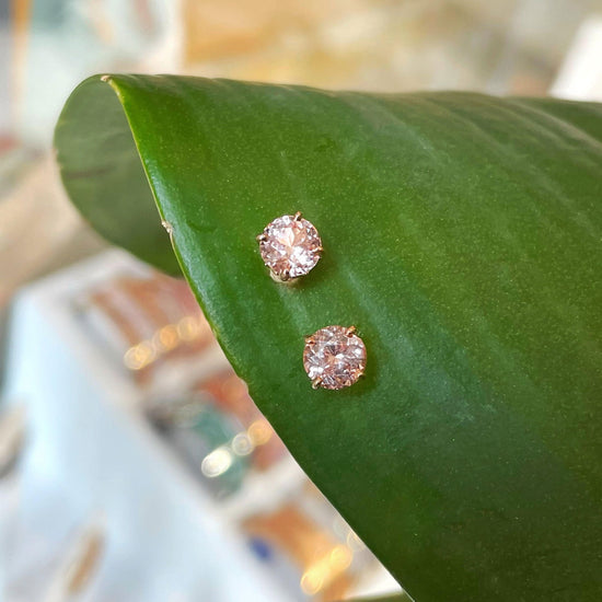 Photo of Pink Garnet Stud Earrings in a decorative scene, designed by , available at Plumb Gold & Plumb Silver