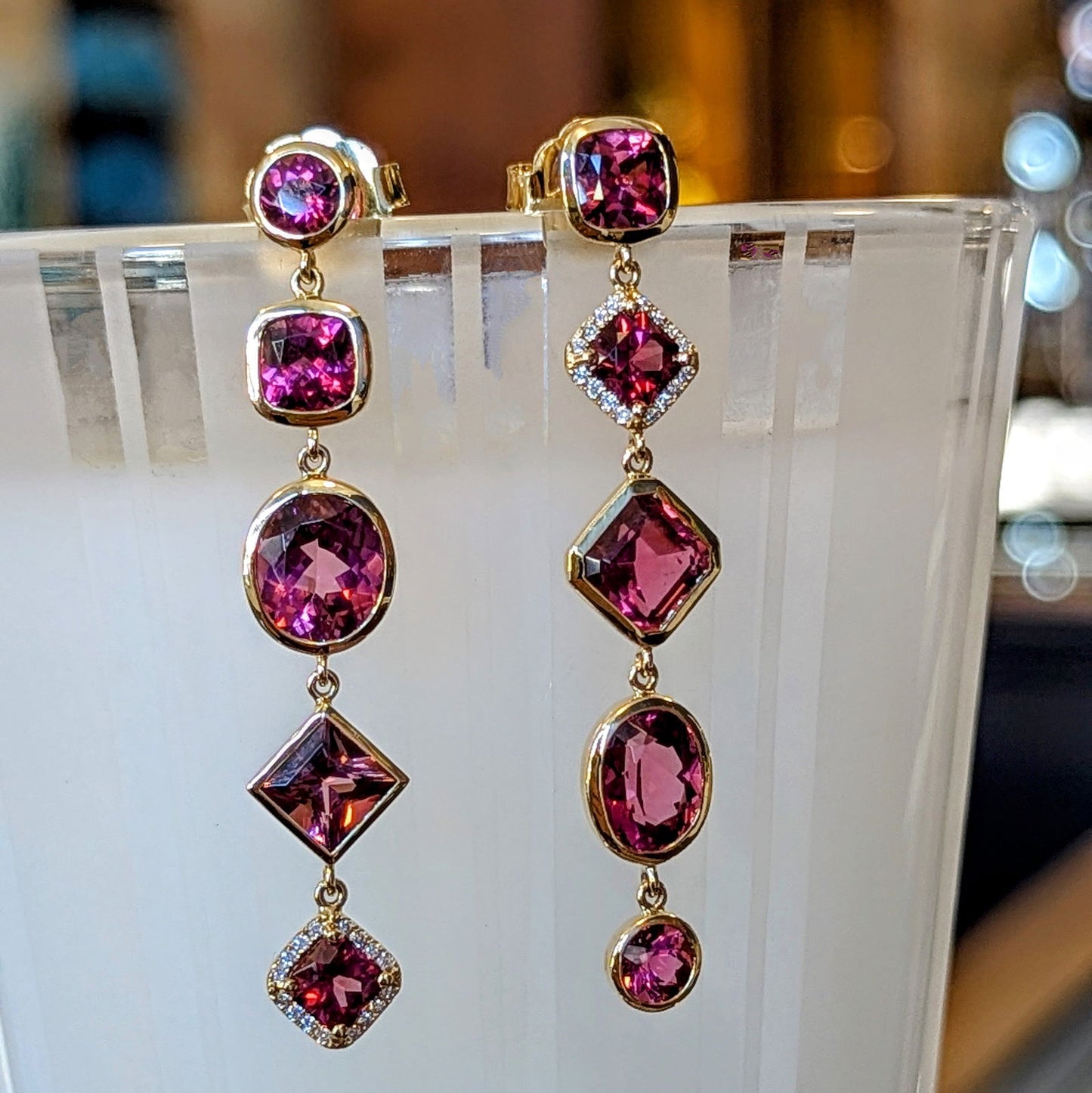 Photo of Pink Multi Dangle Earrings in a decorative scene, designed by , available at Plumb Gold & Plumb Silver