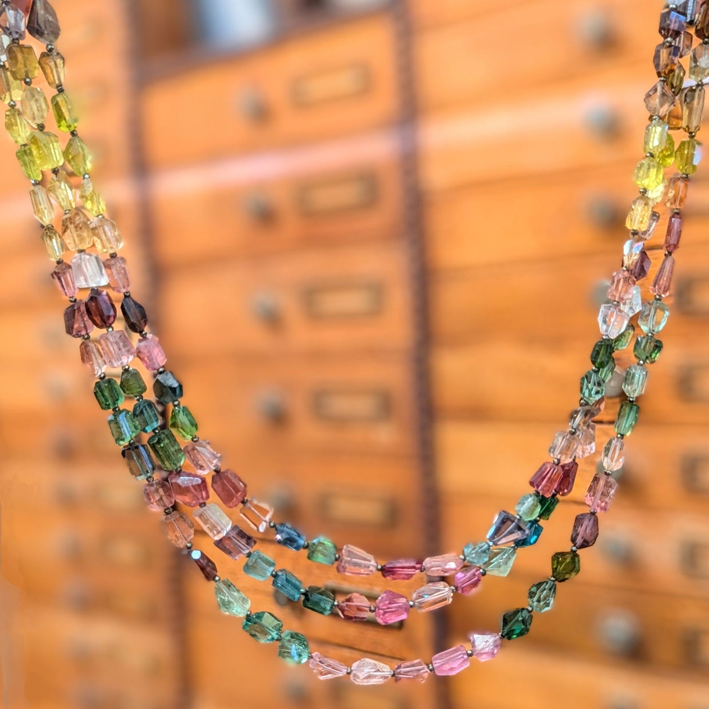 Photo of Plumb Silver Original Rainbow Tourmaline Necklace in a decorative scene, designed by , available at Plumb Gold & Plumb Silver