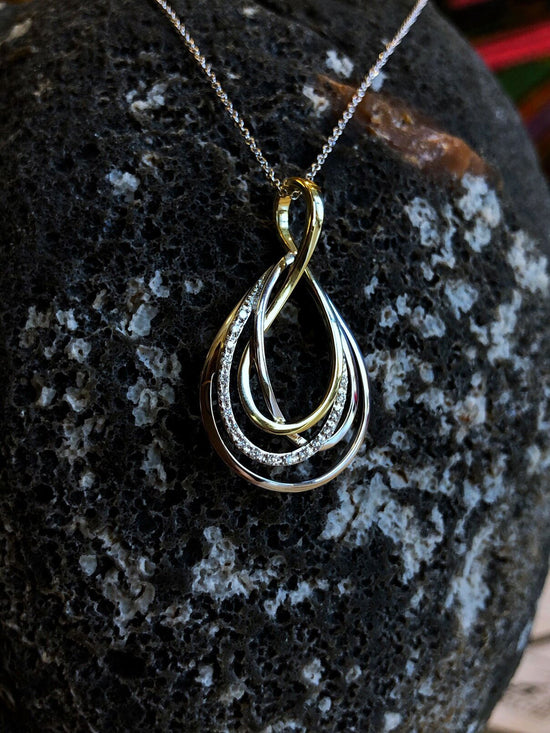 Photo of Quad Loop Diamond Pendant in a decorative scene, designed by , available at Plumb Gold & Plumb Silver