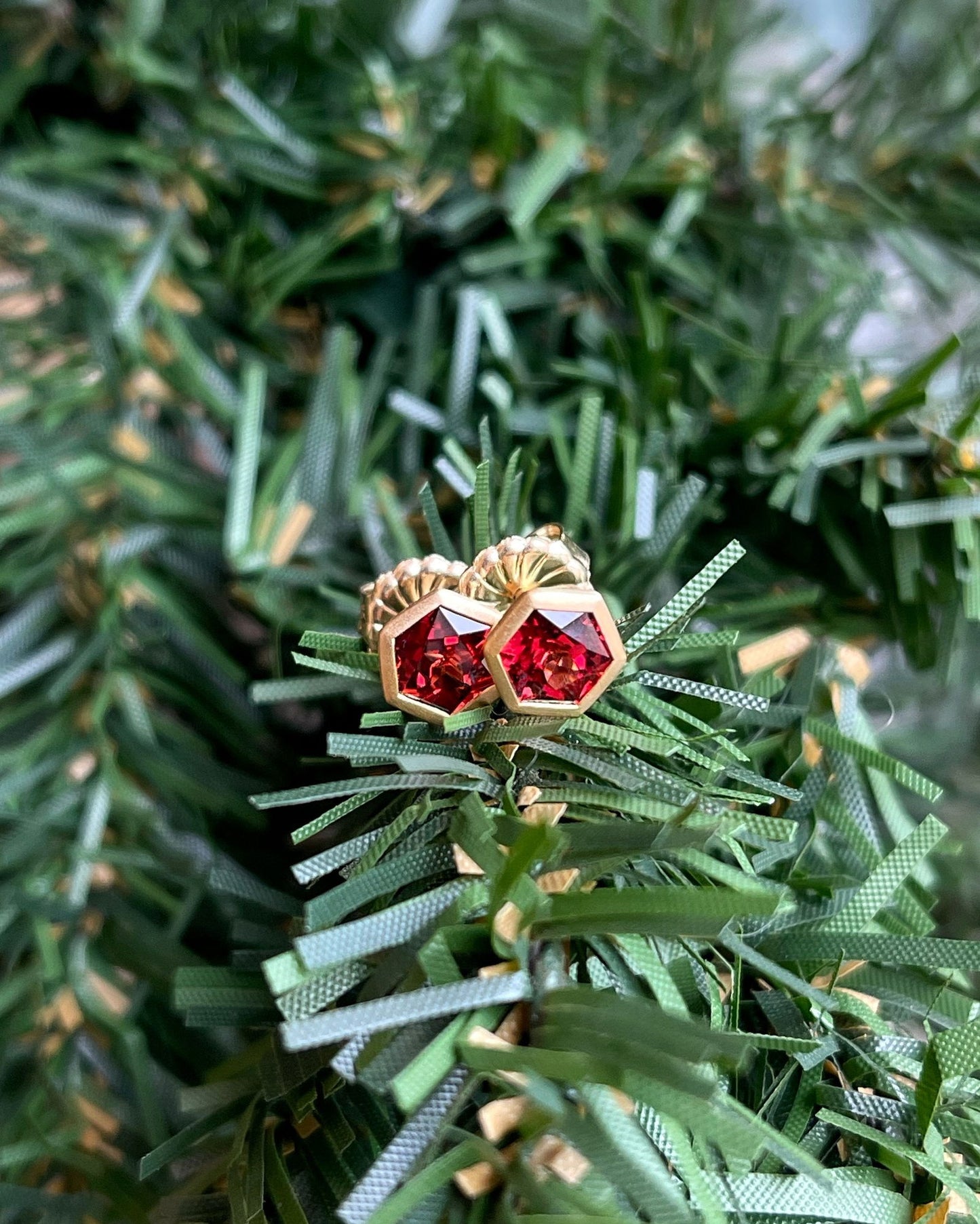 Photo of Red Garnet Studs in a decorative scene, designed by , available at Plumb Gold & Plumb Silver