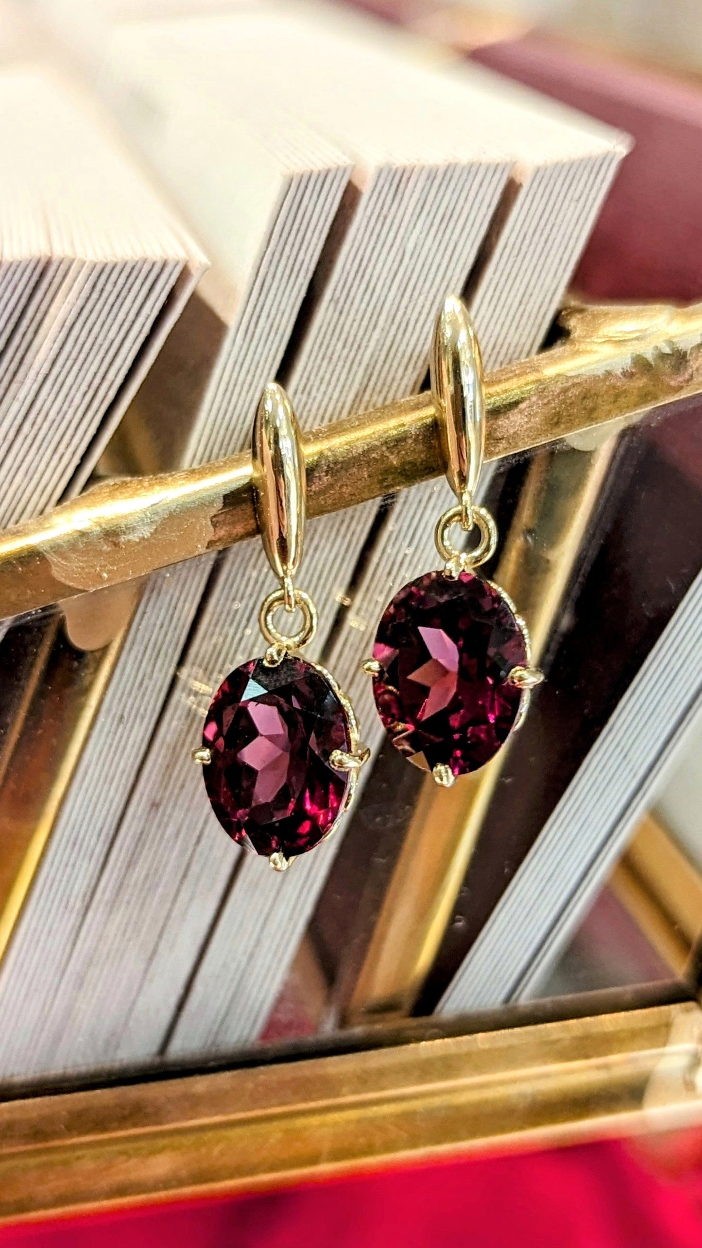 Photo of Rhodolite Dangles in a decorative scene, designed by , available at Plumb Gold & Plumb Silver