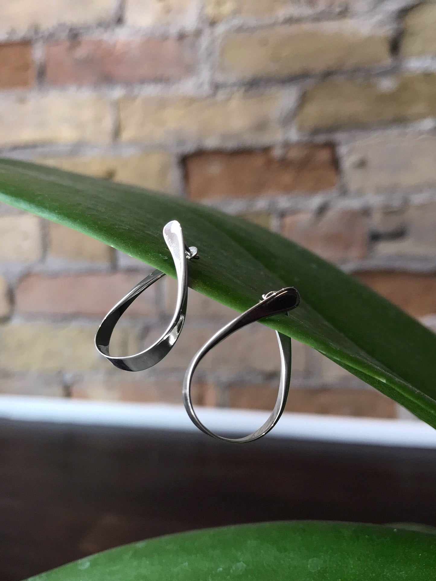 Photo of "Rhythmic Hoop" Earrings in a decorative scene, designed by , available at Plumb Gold & Plumb Silver