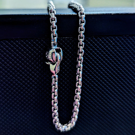 Photo of Rounded Box Chain Bracelet in a decorative scene, designed by , available at Plumb Gold & Plumb Silver