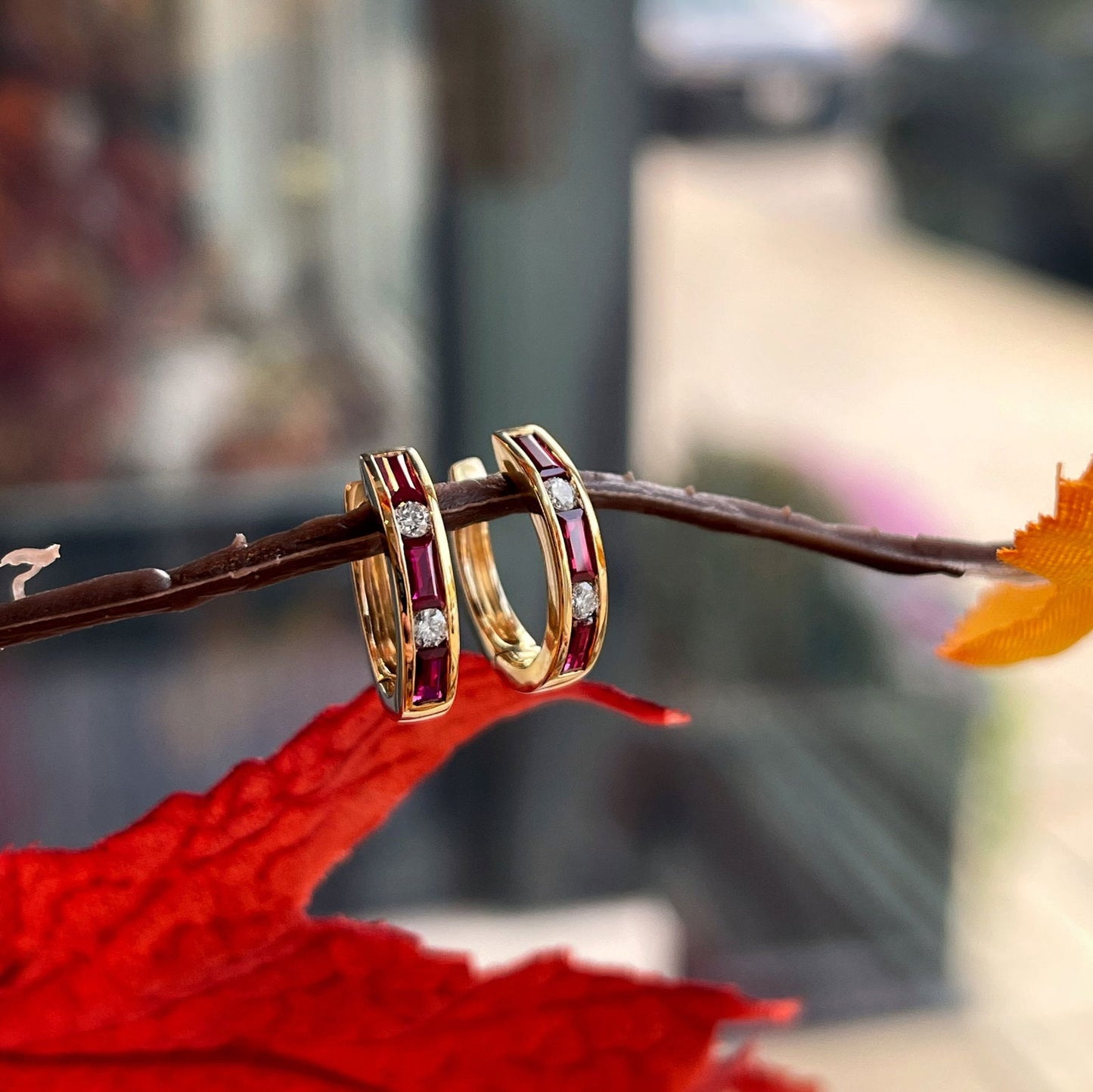 Photo of Ruby and Diamond Hoops in a decorative scene, designed by , available at Plumb Gold & Plumb Silver