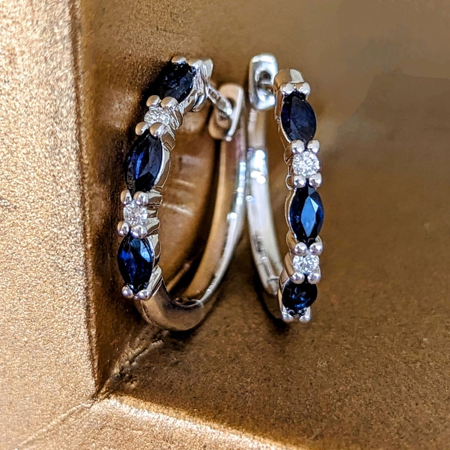 Photo of Sapphire & Diamond Hoops in a decorative scene, designed by , available at Plumb Gold & Plumb Silver