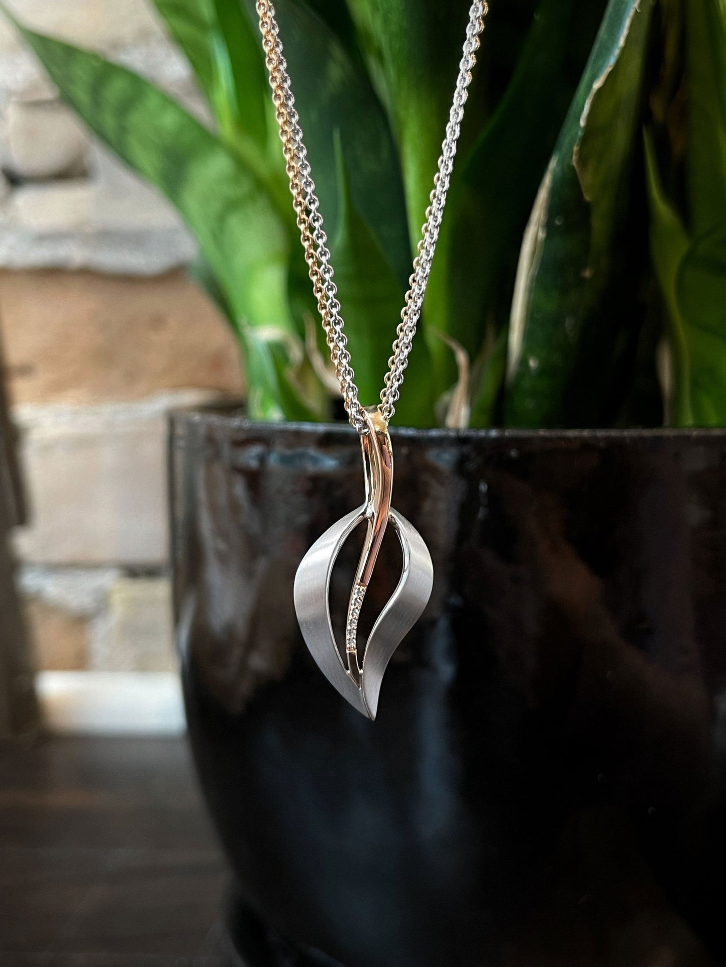 Photo of Satin Leaf Pendant in a decorative scene, designed by , available at Plumb Gold & Plumb Silver