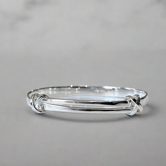 Photo of "Signature Kiss" Bracelet in a decorative scene, designed by , available at Plumb Gold & Plumb Silver