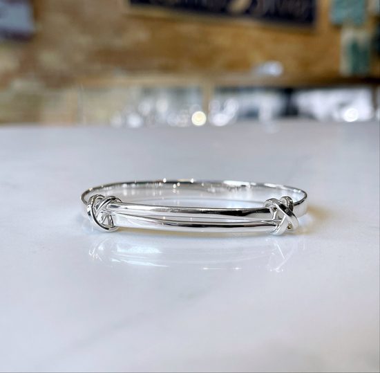 Photo of "Signature Kiss" Bracelet in a decorative scene, designed by , available at Plumb Gold & Plumb Silver