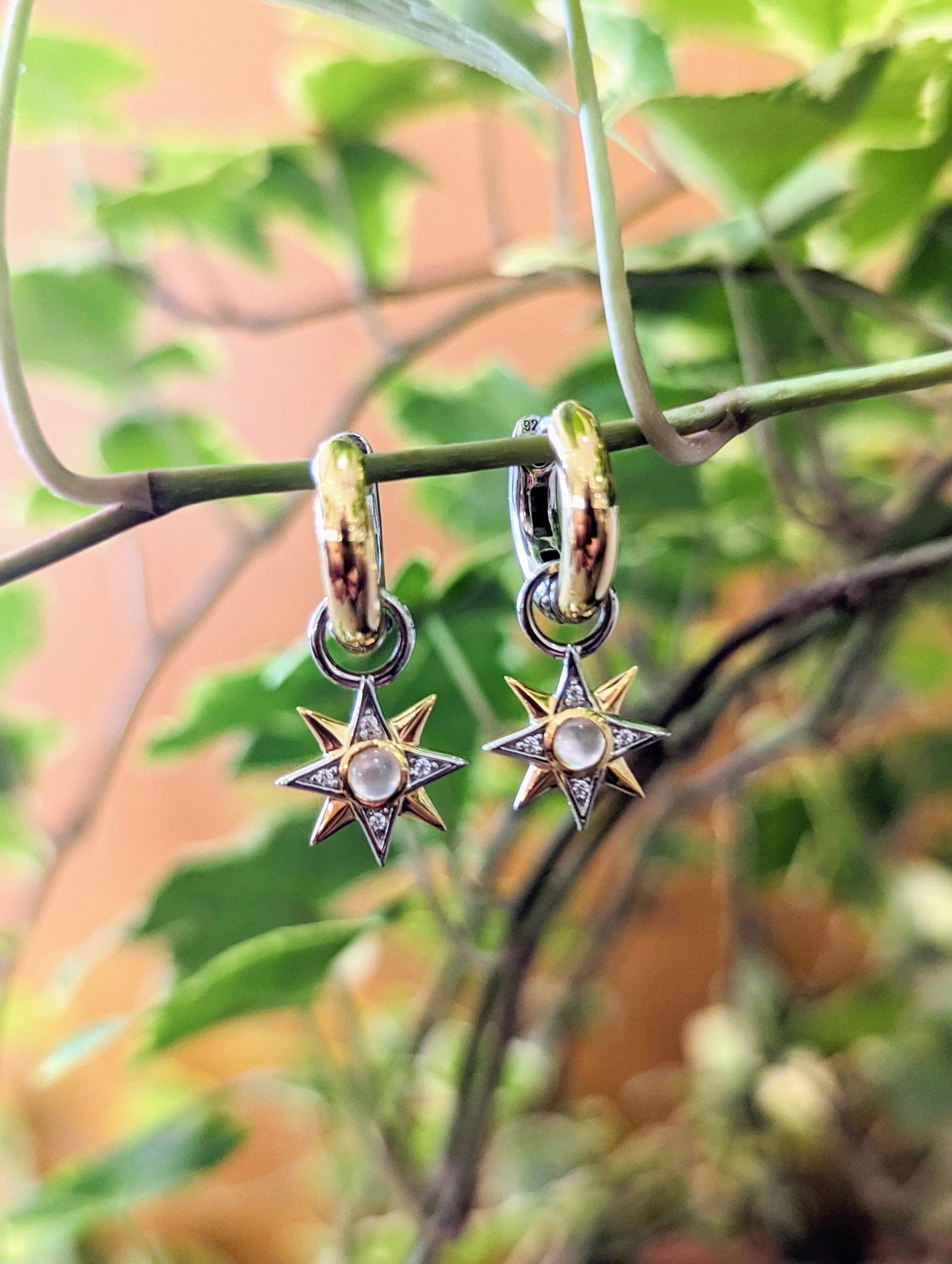 Photo of Small Celestial Hoop Charm in a decorative scene, designed by , available at Plumb Gold & Plumb Silver