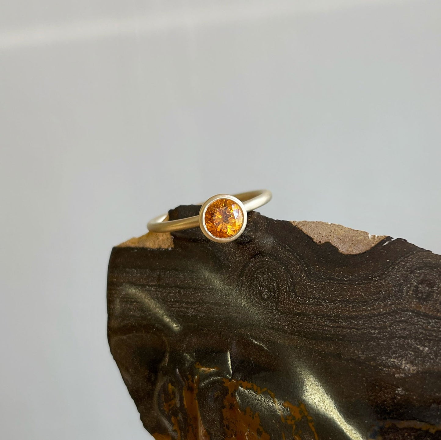 Photo of Spessartite Garnet Yumdrop in a decorative scene, designed by , available at Plumb Gold & Plumb Silver