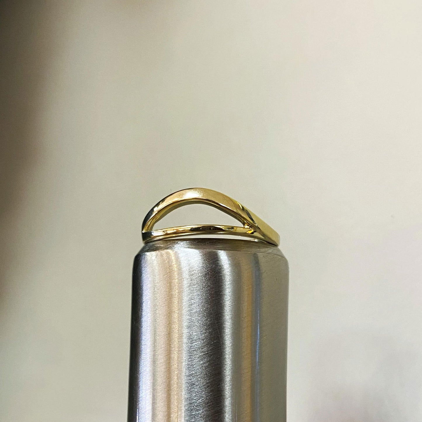 Photo of Split Curved Ring in a decorative scene, designed by , available at Plumb Gold & Plumb Silver