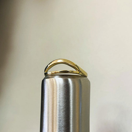 Photo of Split Curved Ring in a decorative scene, designed by , available at Plumb Gold & Plumb Silver