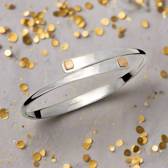 Photo of "Square Swing" Bangle in a decorative scene, designed by , available at Plumb Gold & Plumb Silver