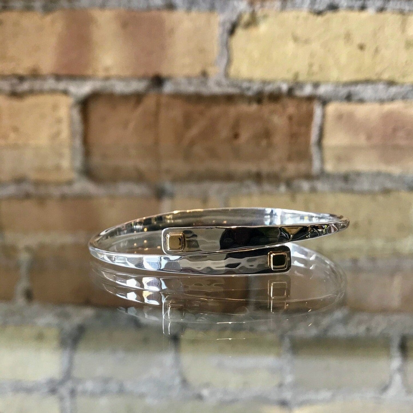 Photo of "Square Swing" Bangle in a decorative scene, designed by , available at Plumb Gold & Plumb Silver